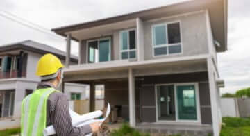 engineer-protective-helmet-blueprints-paper-house-building-construction-site