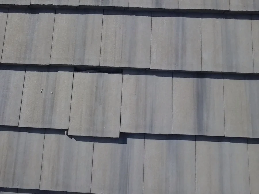 Close-up of cracked concrete roof tiles documented during a Lakewood Ranch warranty inspection.